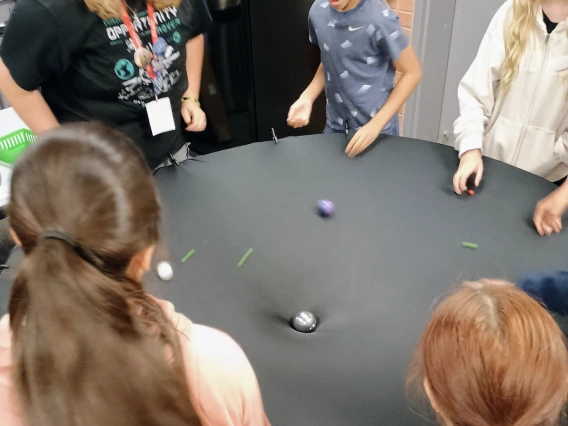 Children surround a gravity well
