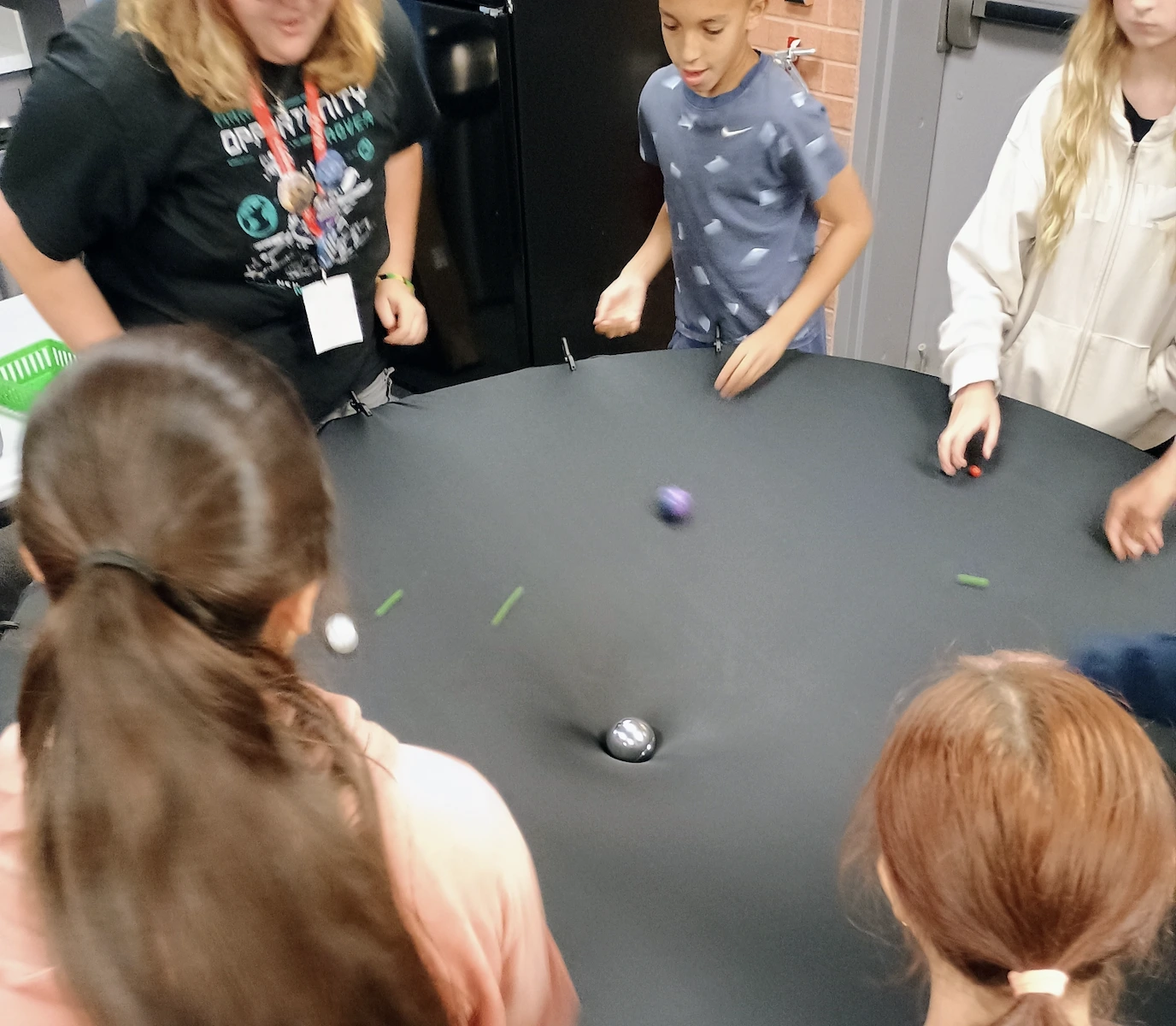 Children surround a gravity well