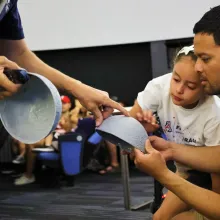 Father and daughter learn about the Moon with a 3d model of the lunar surface at a lecture at Flandrau planetarium in tucson